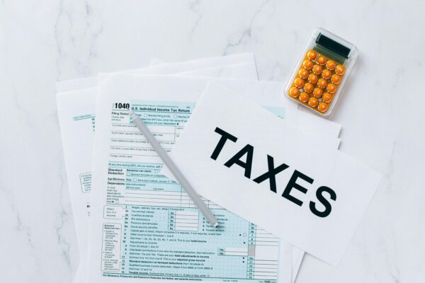 pexels-photo-6863332-6863332 Top view of tax forms, a calculator, and pen for tax preparation.